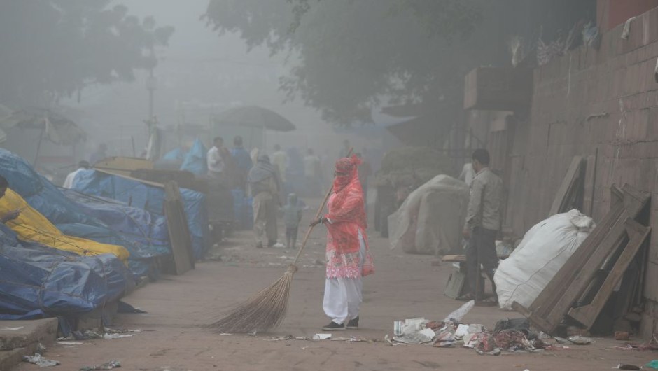 An Indian sweeper cleans a road amid heavy smog in New Delhi on November 8, 2017. Delhi shut all primary schools on November 8 as pollution levels hit nearly 30 times the World Health Organization safe level, prompting doctors in the Indian capital to warn of a public health emergency. Dense grey smog shrouded the roads of the world's most polluted capital, where many pedestrians and bikers wore masks or covered their mouths with handkerchiefs and scarves. / AFP PHOTO / SAJJAD HUSSAIN (Photo credit should read SAJJAD HUSSAIN/AFP/Getty Images)