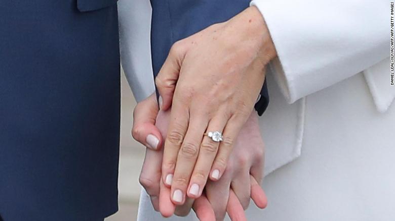 Britain's Prince Harry stands with his fianc??e US actress Meghan Markle as she shows off her engagement ring whilst they pose for a photograph in the Sunken Garden at Kensington Palace in west London on November 27, 2017, following the announcement of their engagement. Britain's Prince Harry will marry his US actress girlfriend Meghan Markle early next year after the couple became engaged earlier this month, Clarence House announced on Monday. / AFP PHOTO / Daniel LEAL-OLIVASDANIEL LEAL-OLIVAS/AFP/Getty Images