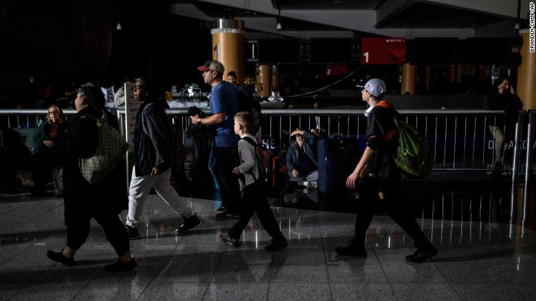 Passengers make their way through Hartfield-Jackson Atlanta International Airport after the lights went out at the airport, Sunday, Dec. 17, 2017, in Atlanta. A sudden power outage at the airport on Sunday grounded scores of flights and passengers during one of the busiest travel times of the year. (AP Photo/Branden Camp)