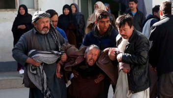 A distraught man is carried following a suicide attack in Kabul, Afghanistan, Thursday, Dec. 28, 2017. Authorities say attackers stormed the Shiite Muslim cultural center in the Afghan capital Kabul, setting off multiple bombs and killing dozens. (AP Photo/Rahmat Gul)