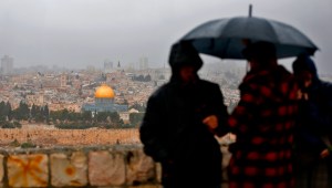 People stand at Mount of Olives and look at the Old City of Jerusalem and its Dome of the Rock mosque in the centre, on December 6, 2017. President Donald Trump is set to recognise Jerusalem as Israel's capital, upending decades of careful US policy and ignoring dire warnings from Arab and Western allies alike of a historic misstep that could trigger a surge of violence in the Middle East. / AFP PHOTO / AHMAD GHARABLI (Photo credit should read AHMAD GHARABLI/AFP/Getty Images)