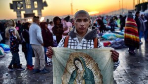A Catholic faithful holds a banner with an image of the Virgin of Guadalupe during a procession as part of the feast of the virgin, patron saint of Mexico, in Mexico City on December 12, 2017. Millions of pilgrims visit Mexico City's Guadalupe Basilica to honour the country's patron saint, the Virgin of Guadalupe. / AFP PHOTO / Pedro PARDO (Photo credit should read PEDRO PARDO/AFP/Getty Images)