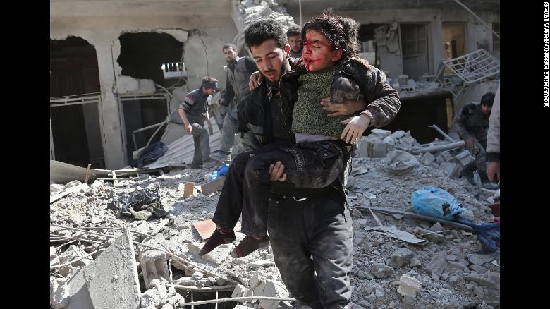 Bombardeo aéreo en Guta Oriental Un hombre rescata a un niño después de un bombardeo del régimen en la ciudad rebelde de Hamouria, en la asediada Guta Oriental, el miércoles 21 de febrero. Unas 300 personas murieron en tres días en los bombardeos en el enclave rebelde, dijeron médicos y activistas.