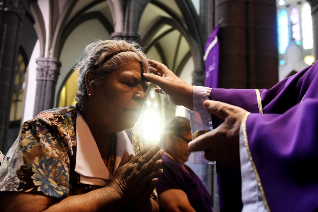 Una mujer recibe la señal de la cruz durante una misa el Miércoles de Ceniza en San Salvador. CRÉDITO: MARVIN RECINOS/AFP/Getty Images