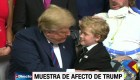 Un niño intenta abrazar a un distraído Trump