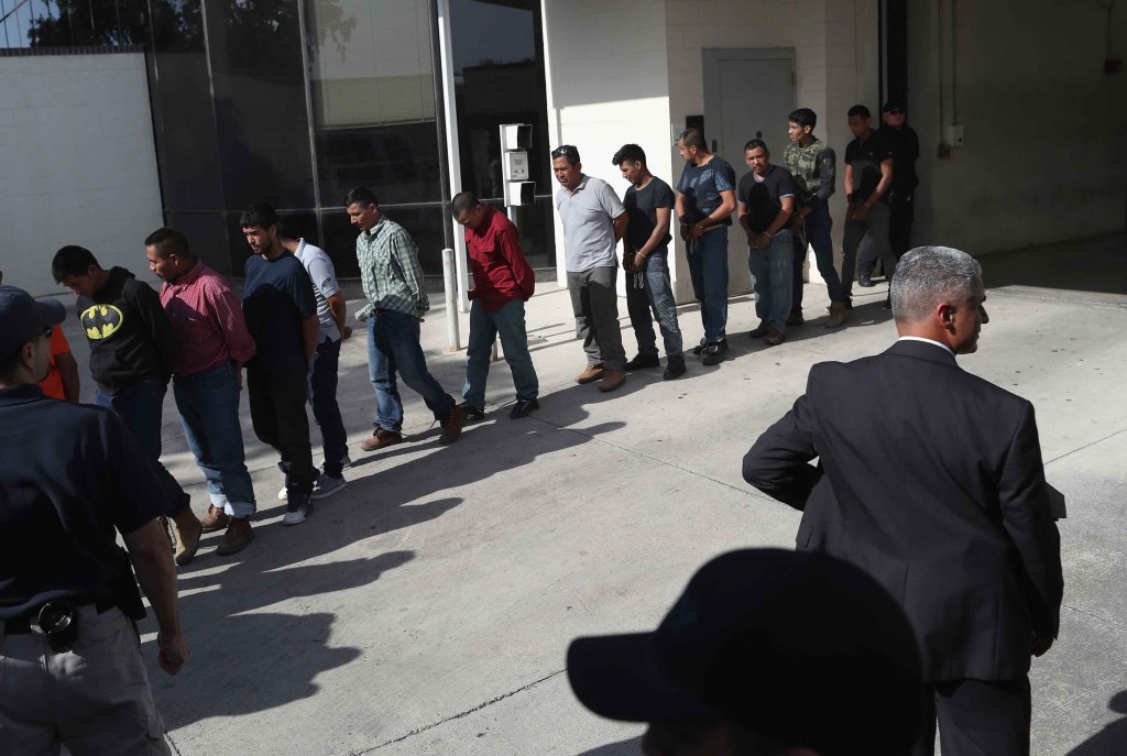 Inmigrantes con grilletes al salir de un tribunal federal de EE. UU. en McAllen, Texas, el lunes 11 de junio. (Crédito: John Moore/Getty Images)