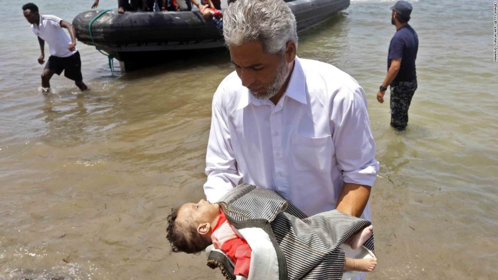 Un hombre lleva el cuerpo de uno de los tres bebés muertos en el Mediterráneo. (Crédito: MAHMUD TURKIA/AFP/Getty Images)