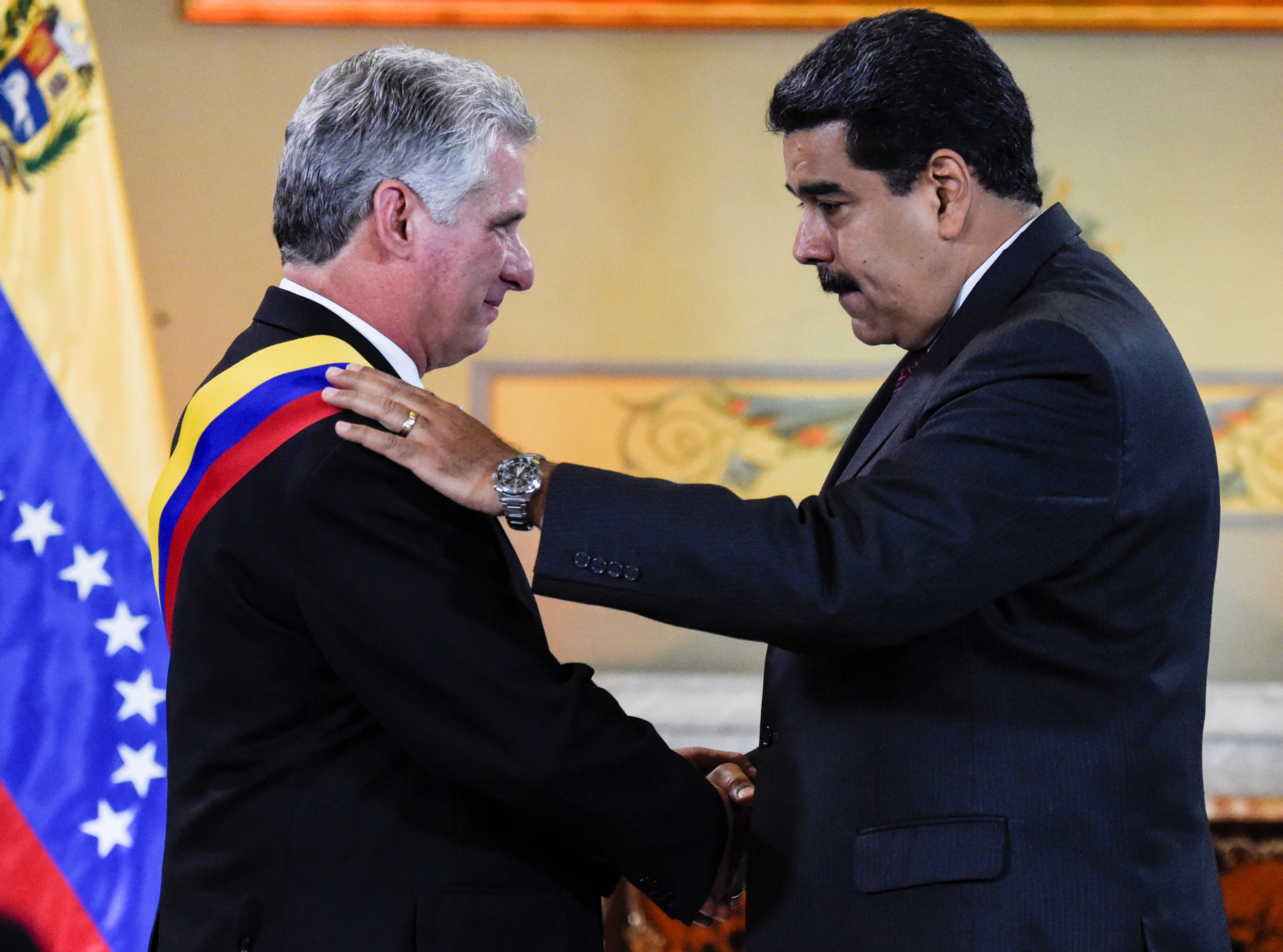 Miguel Díaz Canel se puso la banda presidencial venezolana durante una visita a Nicolás Maduro el 30 de mayo de 2018. (Crédito: JUAN BARRETO/AFP/Getty Images)