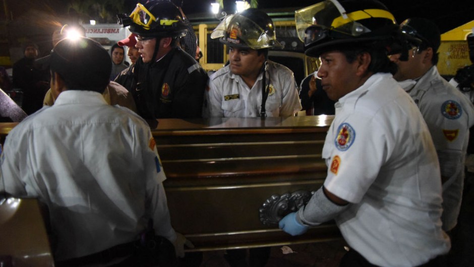 Volunteer firefighters carry a coffin with the body of Sergio Vasquez who died following the eruption of Fuego volcano on June 3, to a morgue in Alotenango municipality, Sacatepequez, about 65 km southwest of Guatemala City, on June 4, 2018. - Emergency workers will resume the search on June 4 for Guatemalans missing after the eruption of the Fuego volcano, which belched out clouds of ash and flows of lava and left at least 25 people dead. (Photo by ORLANDO ESTRADA / AFP) (Photo credit should read ORLANDO ESTRADA/AFP/Getty Images)