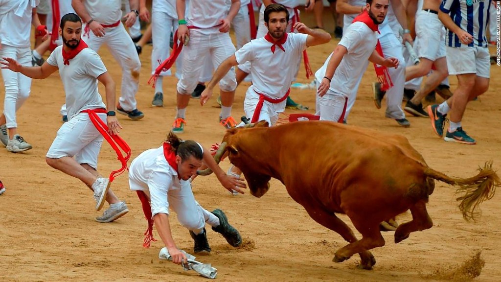 Los aficionados corren delante de los toros con trajes blancos y pañuelos rojos, según marca la tradición. (Crédito: JOSE JORDAN/AFP/Getty Images)