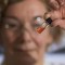 La gerente de laboratorio de biogeoquímica de ANU, Janet Hope, sostiene un vial que contiene los pigmentos intactos más antiguos del mundo.