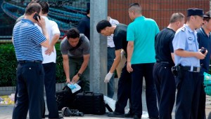 Agentes de seguridad inspeccionan el área tras una explosión cerca de la embajada de Estados Unidos en Beijing, China.
