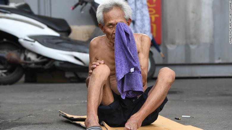 Un anciano se limpia la cara con una toalla durante un día caluroso en un barrio residencial de Seúl.