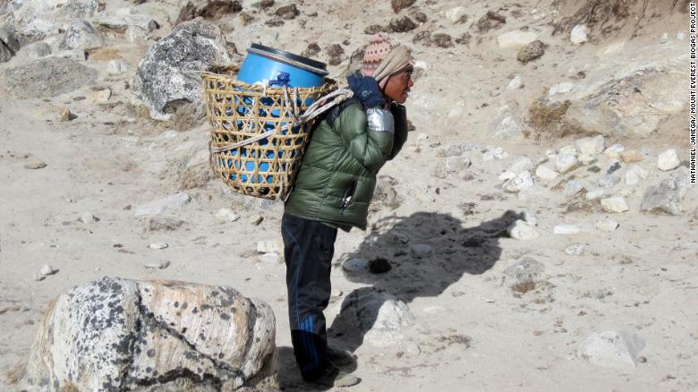 Un porteador en el Everest, que se enfrenta a un problema por acumulación de desechos humanos.