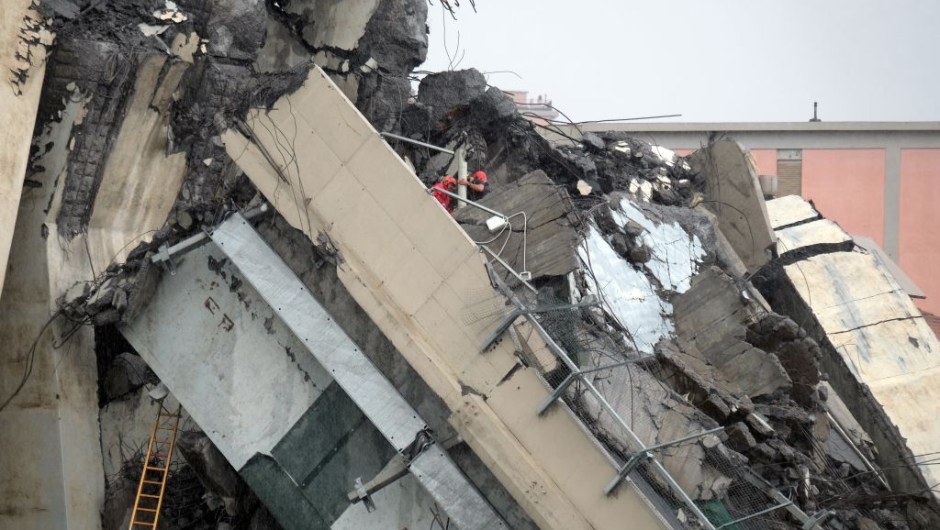 Rescuers are at work amid the rubble of a section of a giant motorway bridge that collapsed earlier, on August 14, 2018 in Genoa. - Rescuers scouring through the wreckage after part of a viaduct of the A10 freeway collapsed said there were "tens of victims", while images from the scene showed an entire carriageway plunged on to railway lines below. (Photo by ANDREA LEONI / AFP) (Photo credit should read ANDREA LEONI/AFP/Getty Images)