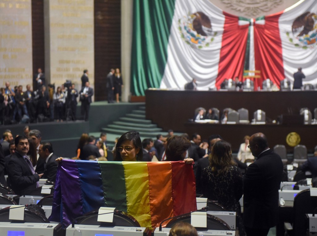 La diputada independiente Lucía Rioja posa con una bandera del arcoíris durante la inauguración de la legislatura LXIV en el Congreso en la Ciudad de México, el 29 de agosto de 2018. (Crédito: RODRIGO ARANGUA/AFP/Getty Images)