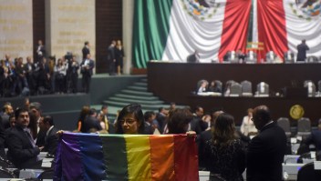 La diputada independiente Lucía Rioja posa con una bandera del arcoíris durante la inauguración de la legislatura LXIV en el Congreso en la Ciudad de México, el 29 de agosto de 2018. (Crédito: RODRIGO ARANGUA/AFP/Getty Images)