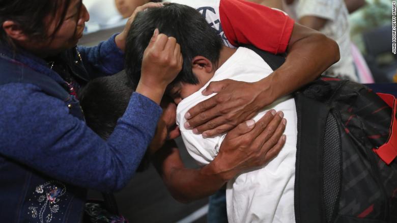 Unos padres abrazan a su hijo por primera vez en meses el 7 de agosto de 2018 en la ciudad de Guatemala, Guatemala.
