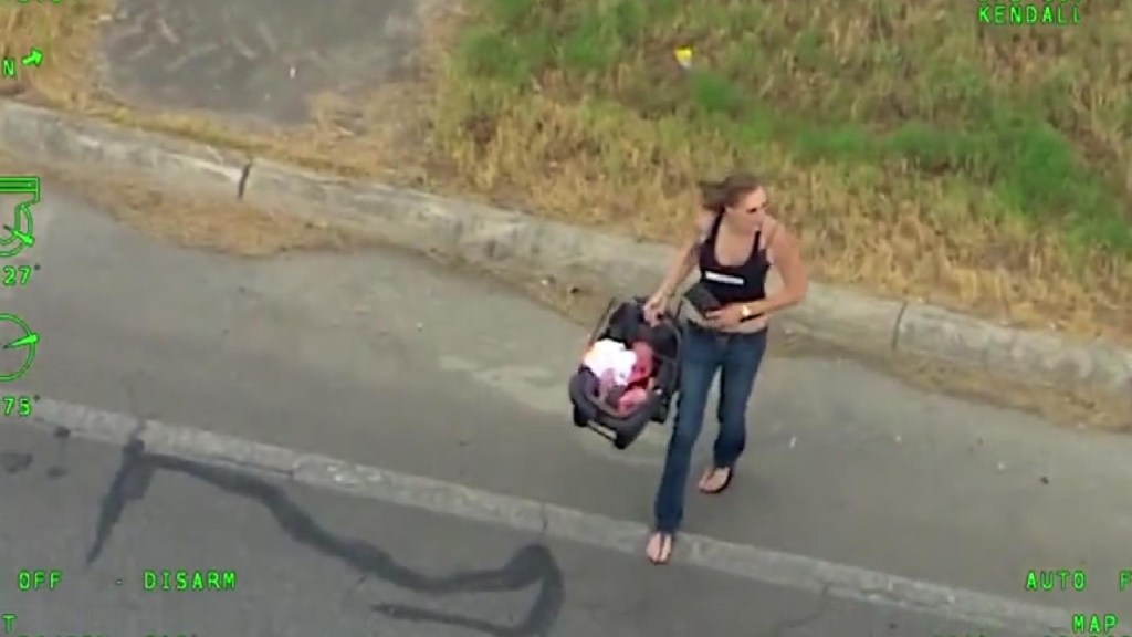 Una mujer huye de la policía cargando un bebé