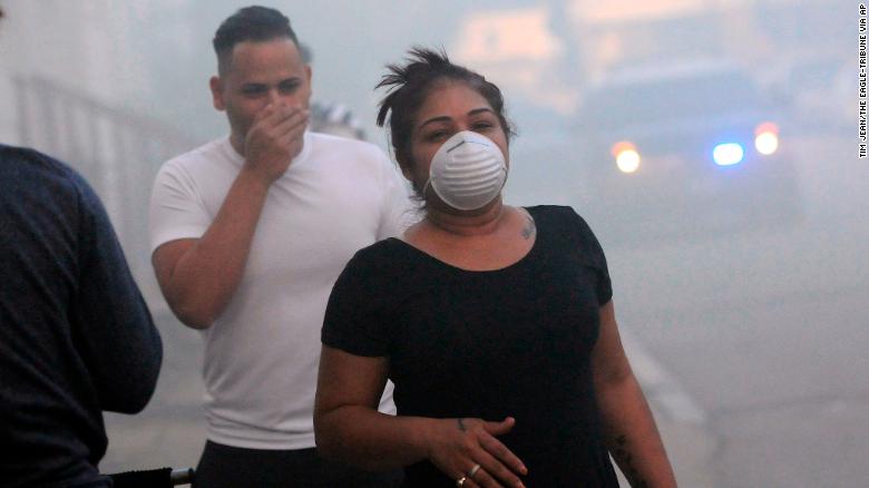 Los residentes se cubren la cara para protegerse del humo mientras evacuaban el jueves en Lawrence, Massachusetts.