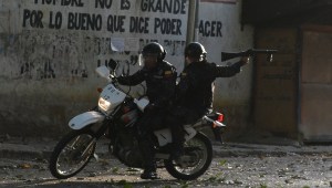 TOPSHOT - A riot policeman on a motorcycle points his gun during clashes with anti-government demonstrators in the neighborhood of Los Mecedores, in Caracas, on January 21, 2019. - A group of soldiers rose up against Venezuela's President Nicolas Maduro at a command post in northern Caracas on Monday, but were quickly arrested after posting an appeal for public support in a video, the government said. (Photo by Federico Parra / AFP) (Photo credit should read FEDERICO PARRA/AFP/Getty Images)