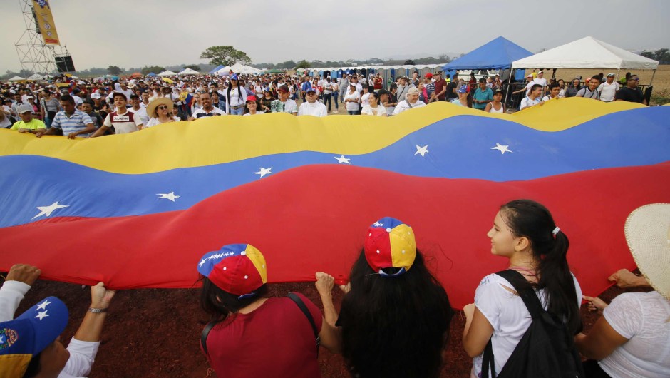 People wait for the start of "Venezuela Aid Live" concert, organized by British billionaire Richard Branson to raise money for the Venezuelan relief effort at Tienditas International Bridge in Cucuta, Colombia, on February 22, 2019 - The concert was organized by British billionaire Richard Branson to raise money for the Venezuelan relief effort. Venezuela's political tug-of-war morphs into a battle of the bands on Friday, with dueling government and opposition pop concerts ahead of a weekend showdown over the entry of badly needed food and medical aid. (Photo by SCHNEYDER MENDOZA / AFP) (Photo credit should read SCHNEYDER MENDOZA/AFP/Getty Images)