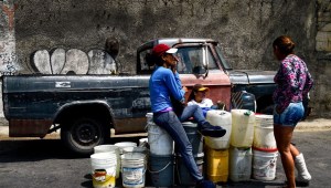People line up with drums to collect water flowing down from the Wuaraira Repano mountain, also called "El Avila", in Caracas on March 13, 2019. - The blackout has left millions without running water. Many people lined up to buy bottled water in Caracas supermarkets, but most are reduced to desperate means -- besieging fountains in public parks and any available water sources around the capital. Marshalled by security forces, crowds formed impatient lines at water trucks in some areas, as they waited to fill containers. But tensions were running high amid the shortages. (Photo by FEDERICO PARRA / AFP) (Photo credit should read FEDERICO PARRA/AFP/Getty Images)