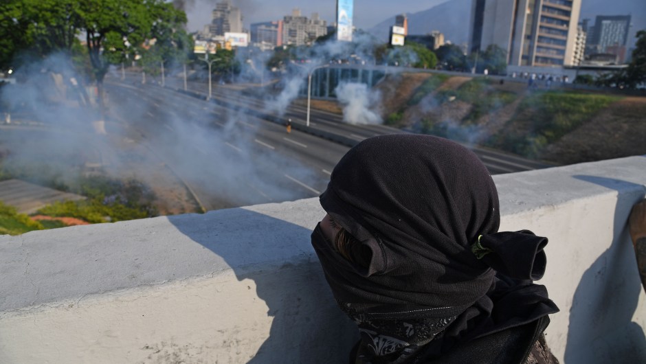 Un hombre se cubre durante los enfrentamientos con las fuerzas de seguridad en Caracas el 30 de abril de 2019. Crédito: YURI CORTEZ / AFP / Getty Images