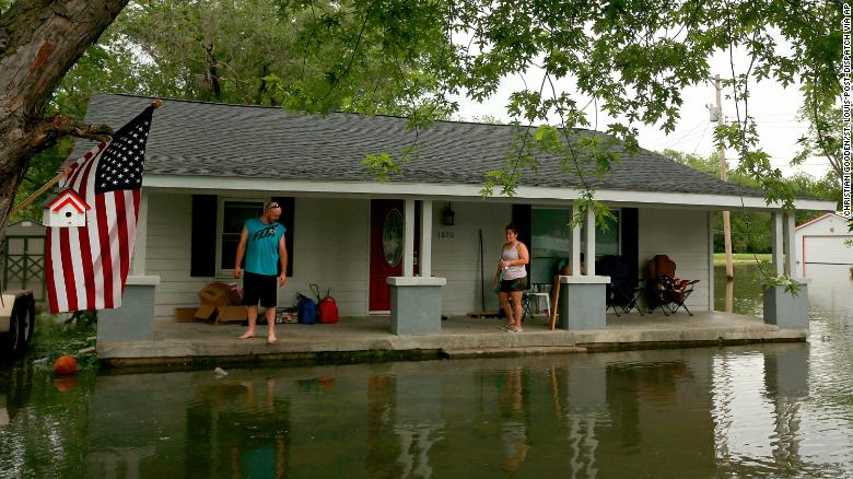 "It'll be in the house by morning" says Nick Sweeney, (left),  as he and his wife Tara watch the water level on Tuesday, May 28, 2019, at their 4th Street home in Portage des Sioux. "We saw a raccoon walking across our front porch," said Tara Sweeney. Photo by Christian Gooden, cgooden@post-dispatch.com