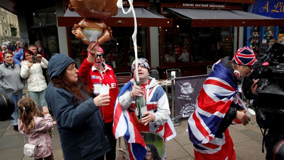 Royal super fans John Loughery (C) pops the cork on a bottle of champagne, as they stand near Windsor Castle in Windsor, west of London on May 6, 2019, following the announcement that Britain's Meghan, Duchess of Sussex has given birth to a son. - Meghan Markle, the Duchess of Sussex, gave birth on Monday to a "very healthy" boy, Prince Harry announced. "We're delighted to announce that Meghan and myself had a baby boy early this morning -- a very healthy boy," a beaming Prince Harry said. (Photo by ADRIAN DENNIS / AFP) (Photo credit should read ADRIAN DENNIS/AFP/Getty Images)