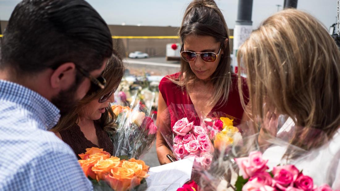 Claudia Portillo, 52, second from right, prays near the site of the Walmart shooting in El Paso, Texas, Tuesday, Aug. 6, 2019. Portillo, an employee at a genetic lab, fled Ciudad Ju??rez with her two children after her husband was killed, looking to start a new life in El Paso over two decades ago. "We don't see hate crimes out here," Portillo said. "I'm reliving those memories of living in Ju??rez back in the 90s. You are looking behind your back all the time, that's what I caught myself doing."