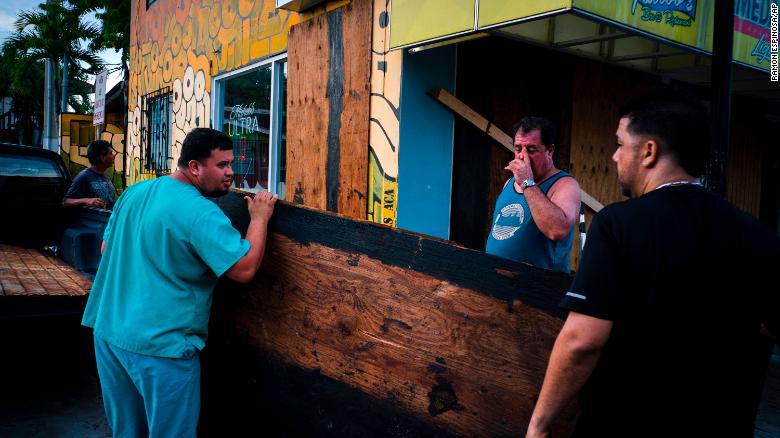 Men board up a shop's windows ahead of the arrival of Tropical Storm Dorian in Boqueron, Puerto Rico, Tuesday, Aug. 27, 2019. (AP Photo/Ramon Espinosa)
