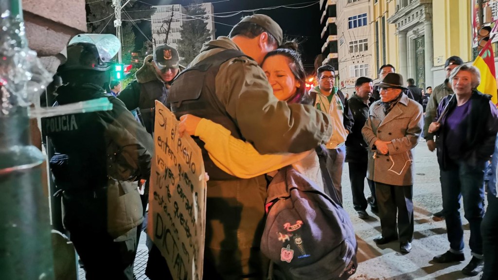Un policía y una manifestante se abrazan por la paz