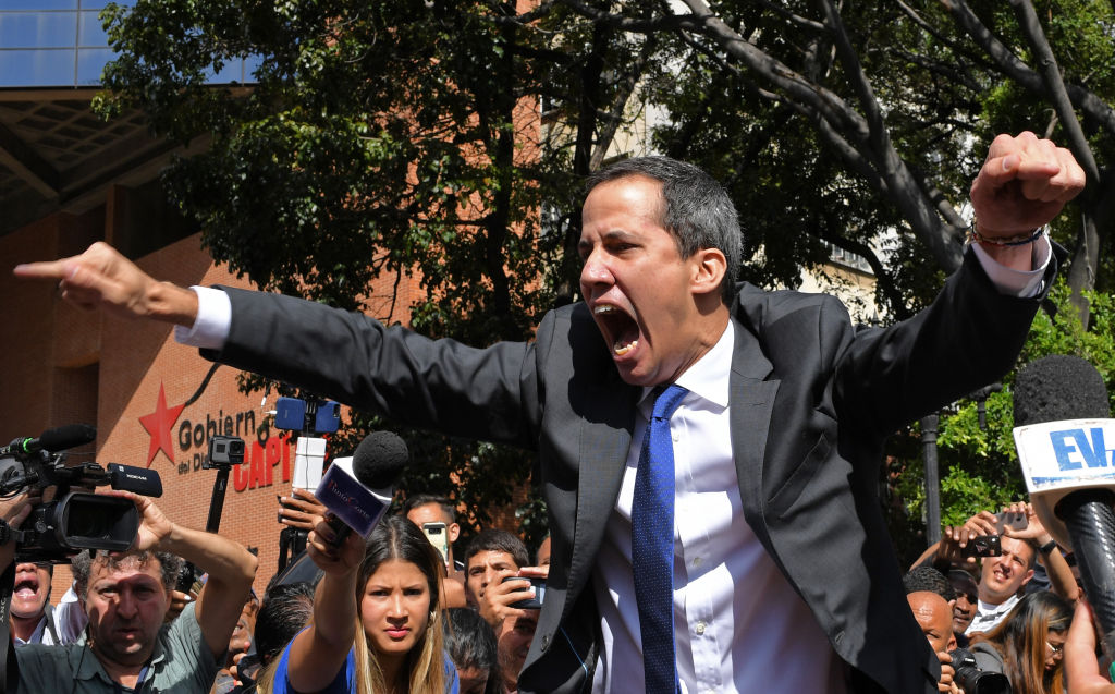 Venezuelan opposition leader and self-proclaimed acting president Juan Guaido shouts surrounded by journalists on his way to the National Assembly, in Caracas, on January 7, 2020. - Opposition leader Juan Guaido and a rival lawmaker, Luis Parra -who both had claimed to be Venezuela's parliament speaker, following two separate votes and accusations of a "parliamentary coup- called for a parliamentary session today. (Photo by Yuri CORTEZ / AFP) (Photo by YURI CORTEZ/AFP via Getty Images)
