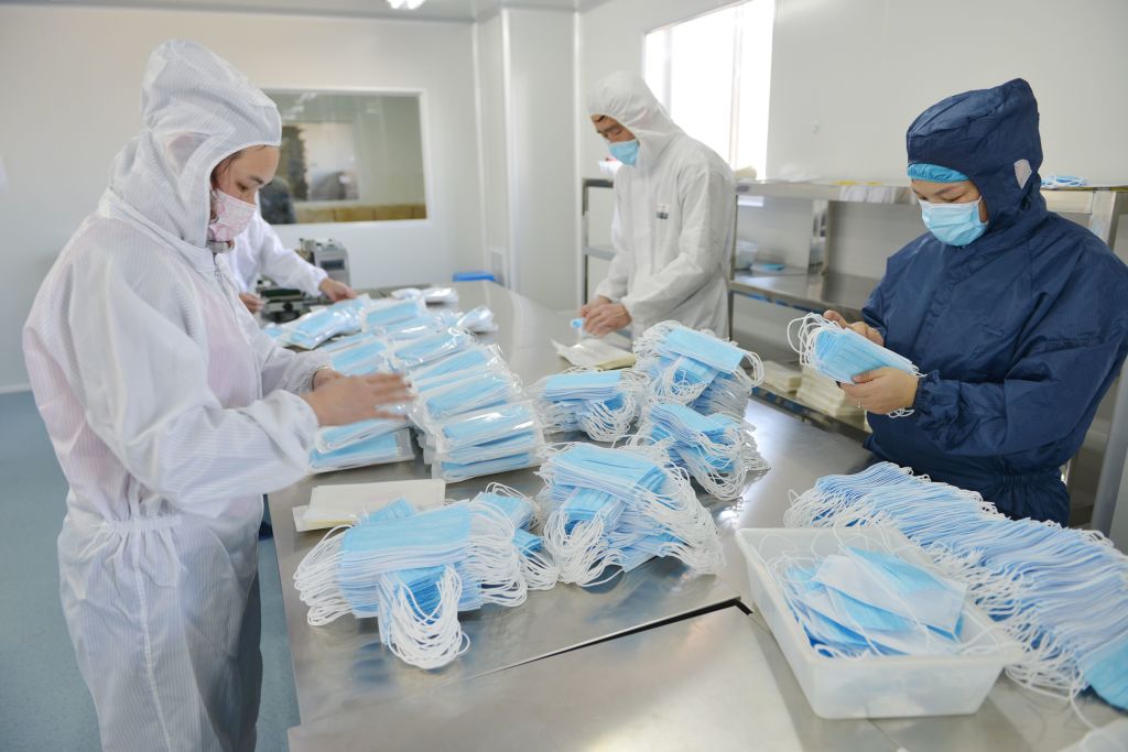 This photo taken on February 18, 2020 shows workers making face masks to satisfy increased demand during China's COVID-19 coronavirus outbreak, at a factory in Nanjing, in China's Jiangsu province. - The medical equipment factory switched surgical instruments and dental equipment production lines to a mask production line to meet the increased demand. (Photo by STR / AFP) / China OUT (Photo by STR/AFP via Getty Images)