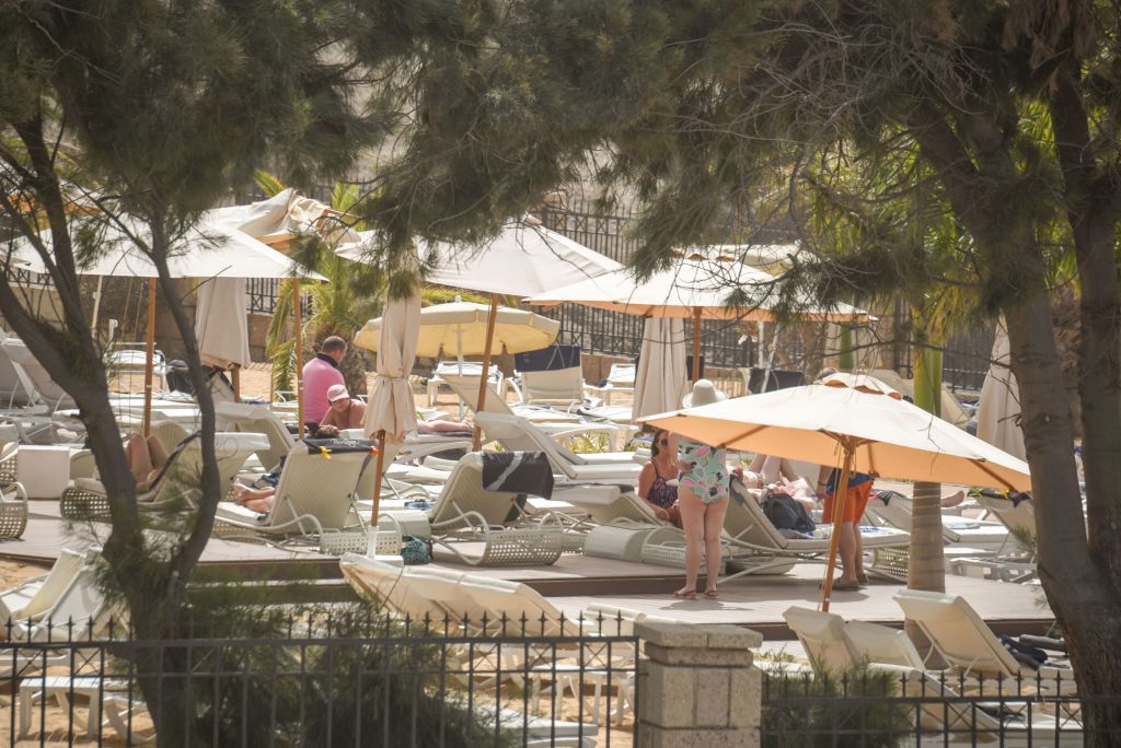 Tourists sunbath at the H10 Costa Adeje Palace Hotel in La Caleta, on February 25, 2020, where hundreds of people were confined after an Italian tourist was hospitalised with a suspected case of coronavirus. - Tourists staying in a four-star hotel on the Spanish island of Tenerife, in the Canary archipielago, were confined to their rooms today following the announcement of a suspected novel coronavirus, COVID-19, case waiting for official confirmation. This possible case was detected yesterday in Tenerife, where an Italian national passed a first test which turned out to be positive, announced the Spanish Ministry of Health. (Photo by DESIREE MARTIN / AFP) (Photo by DESIREE MARTIN/AFP via Getty Images)