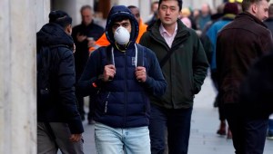 A pedestrian is seen wearing a surgical face mask on Regents Street in central London on February 27, 2020. - European and US stock markets slumped heavily again Thursday as new coronavirus infections spread outside China. Around 2,800 people have died in China and more than 80,000 have been infected. There have been more than 50 deaths and 3,600 cases in dozens of other countries, raising fears of a pandemic. (Photo by Niklas HALLE'N / AFP) (Photo by NIKLAS HALLE'N/AFP via Getty Images)