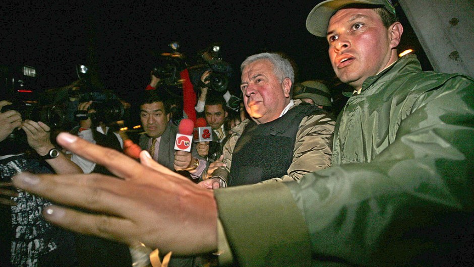 BOGOTA, COLOMBIA: Gilberto Rodriguez Orejuela (L), head of the Cali drug cartel, is escorted at the narcotic-police airport in Bogota, to a plane that will take him in extradition to the United States, 03 December 2004. Colombian President Alvaro Uribe gave earlier in the day his final approval of Rodriguez Orejuela's deportation - and his handover to the US Drug Enforcement Administration . The wily 64-year-old drug kingpin nicknamed "The Chess Player" has been in detention since 1995. He and his bother Miguel headed one of the largest drug trafficking organizations in the world. AFP PHOTO/Luis ACOSTA (Photo credit should read LUIS ACOSTA/AFP via Getty Images)