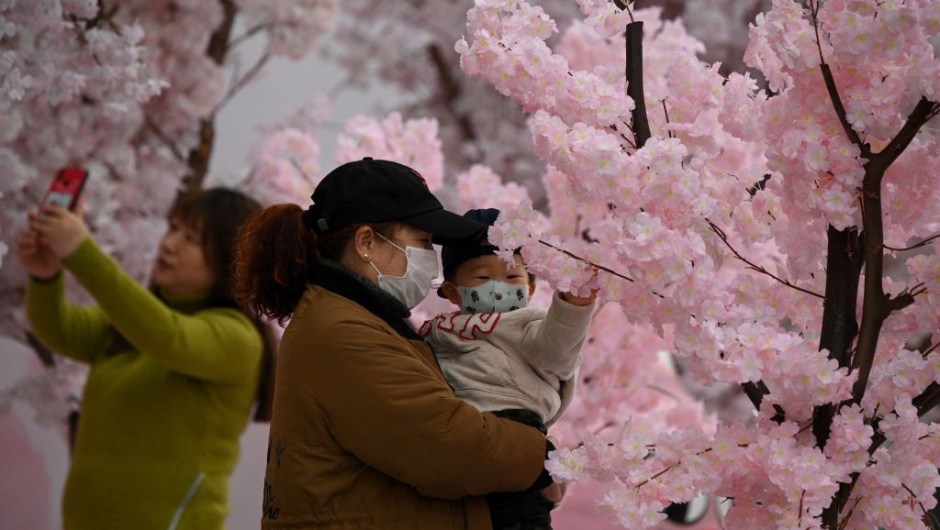 TOPSHOT - People wearing facemasks are seen near a mall in Nanjing, east China's Jiangsu Province on March 12, 2020. - The new coronavirus outbreak "is a controllable pandemic" if countries step up measures to tackle it, the head of the World Health Organization said. (Photo by NOEL CELIS / AFP) (Photo by NOEL CELIS/AFP via Getty Images)