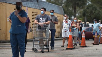 MIAMI, FLORIDA - APRIL 13: Customers wearing masks line up to shop at the Presidente Supermarket on April 13, 2020 in Miami, Florida. The employees at Presidente Supermarket, like the rest of America's grocery store workers, are on the front lines of the coronavirus pandemic, helping to keep the nation's residents fed. (Photo by Joe Raedle/Getty Images)