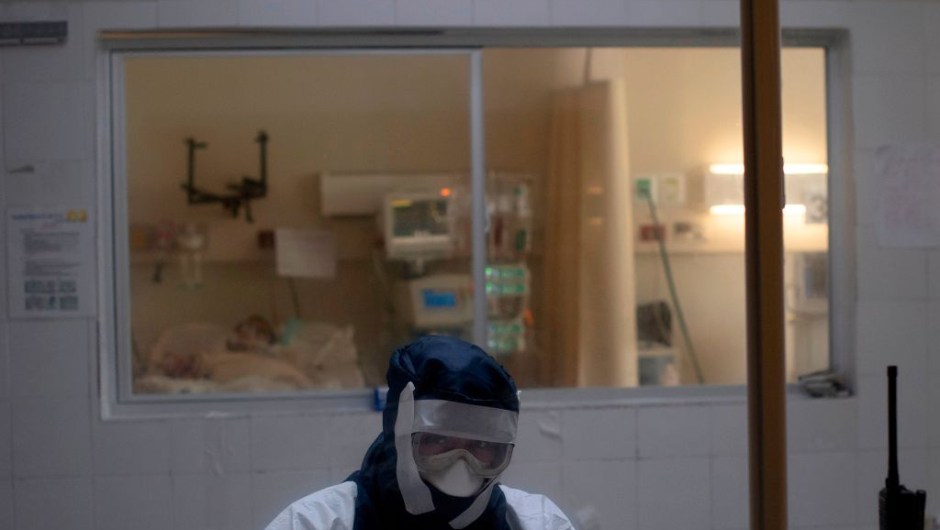 A doctor remains in an observation cabin in front of a patient infected with the novel coronavirus COVID-19, in the intensive care unit of the San Rafael Hospital in Santa Tecla, La Libertad, just 10 km from the Salvadorean capital San Salvador, on May 16, 2020. - The San Rafael Hospital, which has been assigned to care for 100 COVID-19 patients whose cases range from "severe to critical," is leading in their recovery, and part of the success, according to hospital director Yeerles Luis Ramirez, has been early treatment. (Photo by Yuri CORTEZ / AFP) (Photo by YURI CORTEZ/AFP via Getty Images)