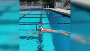 Nadadora olímpica cruza piscina con un vaso en la cabeza