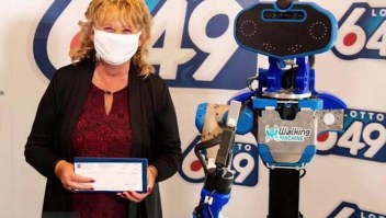 Robot entrega cheque millonario a ganadora de la lotería