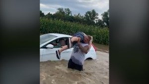 Un buen samaritano saca a personas de un auto inundado