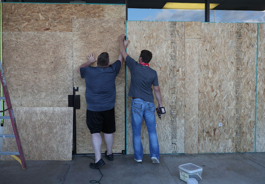 LAKE CHARLES, LOUISIANA- AUGUST 25: (L-R) Tyler Arnold and David Lohr work on placing plywood over the windows of a business before the arrival of Hurricane Laura on August 25, 2020 in Lake Charles, Louisiana. Laura is expected to hit somewhere along the Gulf Coast late Wednesday and early Thursday. (Photo by Joe Raedle/Getty Images)