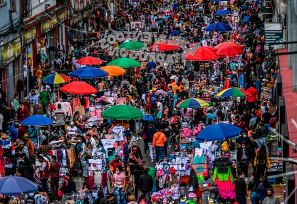 TOPSHOT - People shop for Christmas gifts at a commercial street in the San Victorino neighborhood of Bogota on December 21, 2020, amid the new coronavirus pandemic. - The main cities in Colombia announced Monday restrictions that affect some 15 million people due to an increase in the speed of contagion of the new coronavirus in the framework of the Christmas festivities (Photo by Juan BARRETO / AFP) (Photo by JUAN BARRETO/AFP via Getty Images)