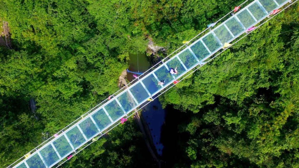 Tourist pende da un ponte di vetro in Cina