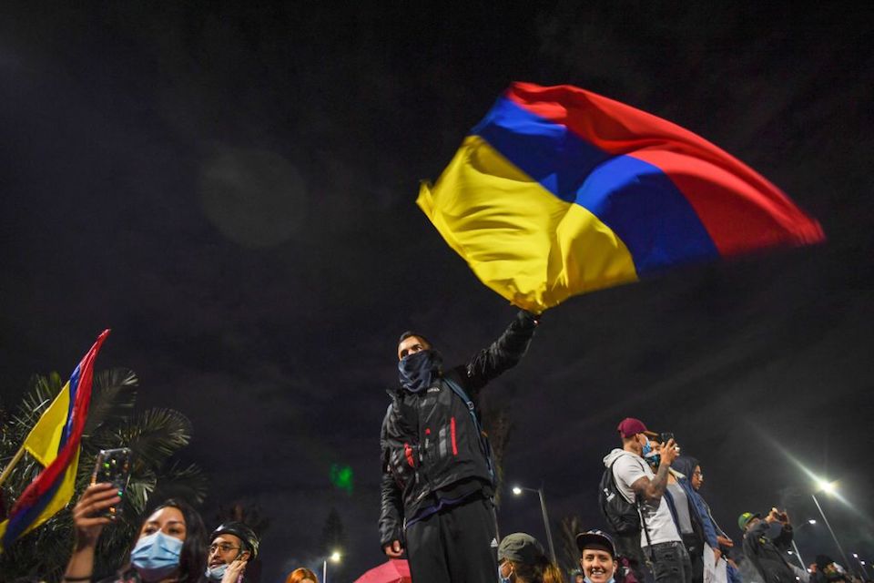 A man flutters a Colombian flag during a protest against President Ivan Duque's government in Bogota, on May 6, 2021. - Colombia's government on Thursday invited protest leaders to a dialogue in an attempt to calm tensions following more than a week of deadly demonstrations against President Ivan Duque. (Photo by Juan BARRETO / AFP) (Photo by JUAN BARRETO/AFP via Getty Images)