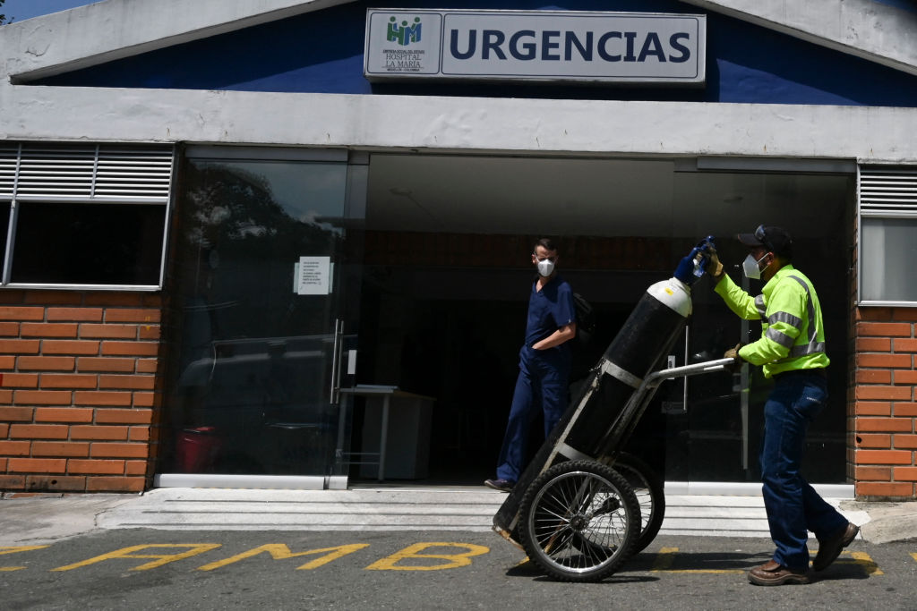 A worker pushes an oxygen tank at a hospital, amid the COVID-19 pandemic, in Medellin on April 22, 2021. (Photo by JOAQUIN SARMIENTO / AFP) (Photo by JOAQUIN SARMIENTO/AFP via Getty Images)