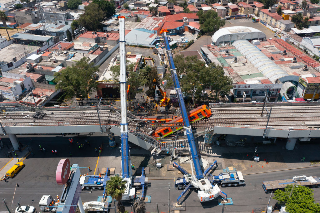 MEXICO CITY, MEXICO - MAY 04: Aerial view of the works to remove the damaged train after a train overpass collapsed last night killing 23 people on May 04, 2021 in Mexico City, Mexico. The accident happened between Olivos and Tezonco stations of metro line 12 at 10pm local time. (Photo by Hector Vivas/Getty Images)